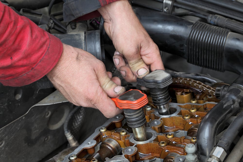 Car mechanic replacing ignition coil on gasoline engine