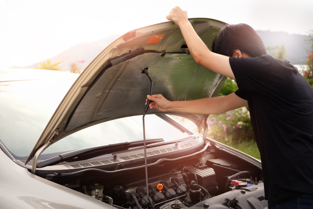 Man popping the hood of a car