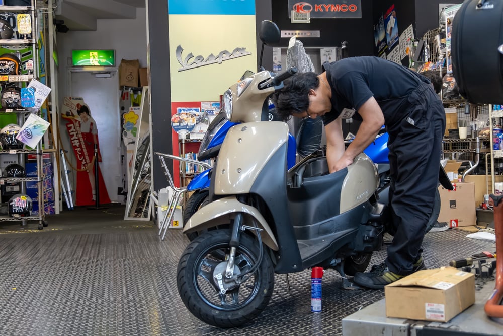 man assembling gas scooter in garage