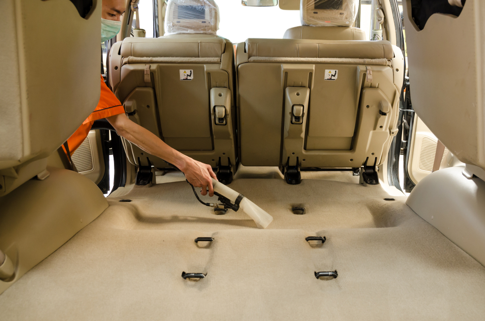 cleaner vacuuming the car carpet