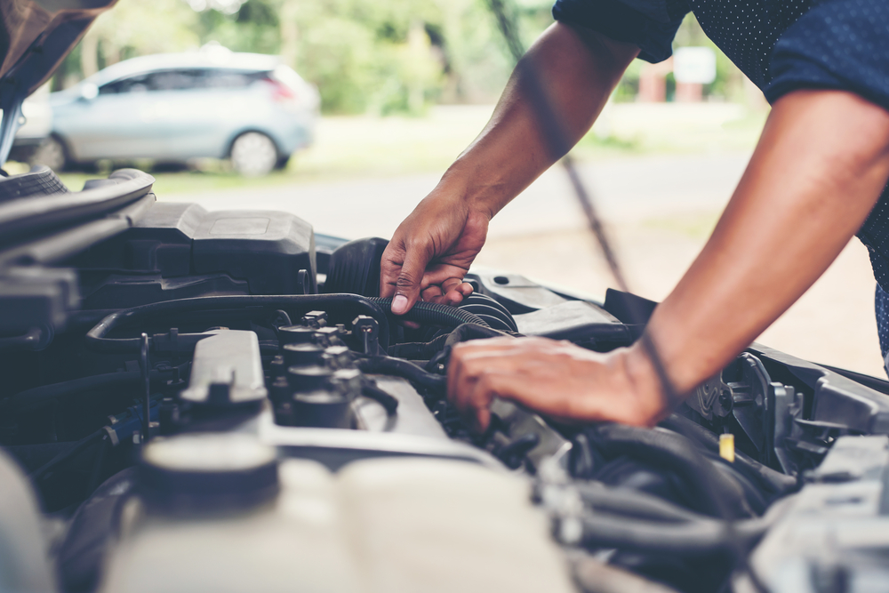 man checking car engine