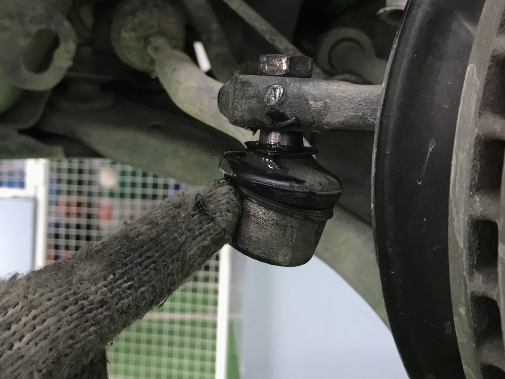 a greased tie rod end attached to a car’s rotor