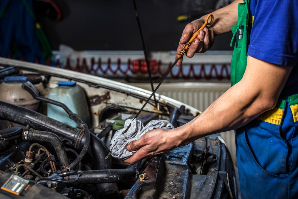 Mechanic checking the oil level in a car