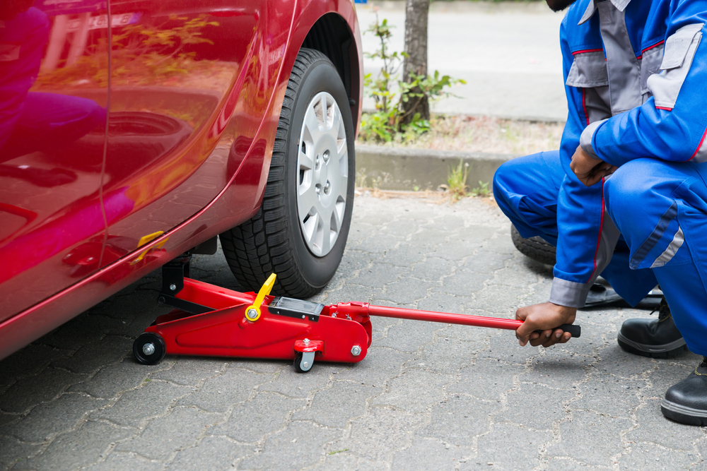 kneeling mechanic using hydraulic jack