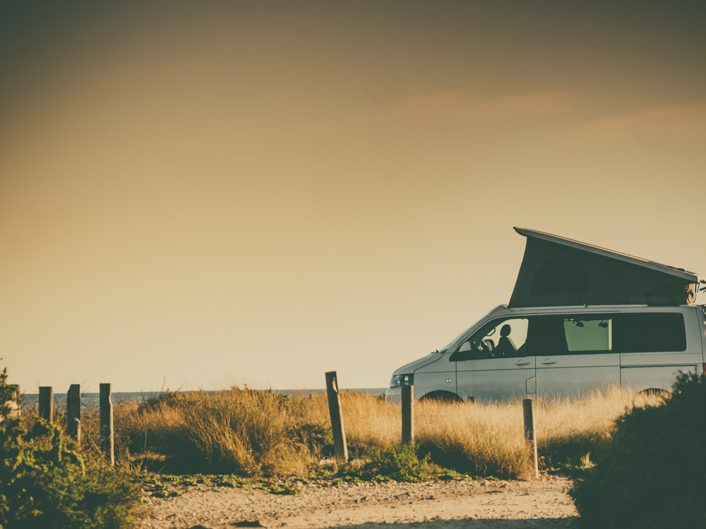 A hard shell roof top tent on a camper van