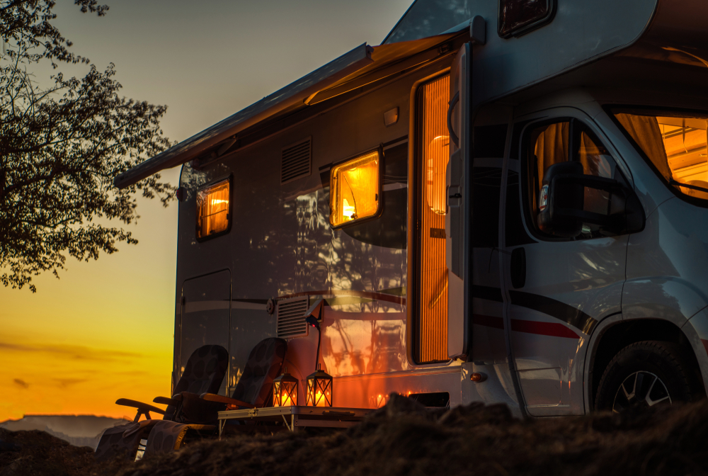 RV with the lights on at sunset