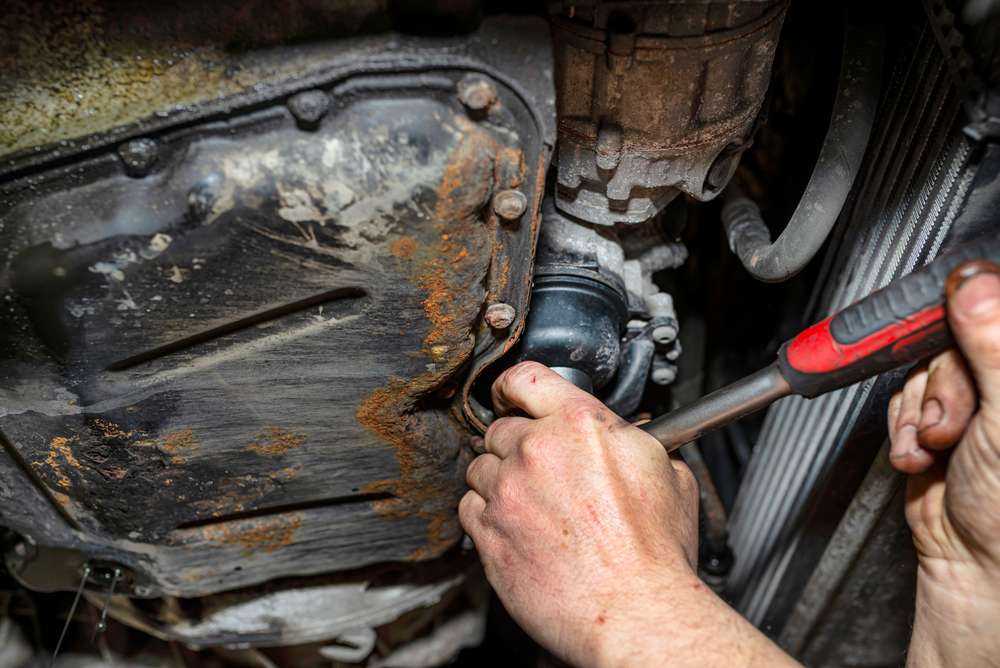 cap style filter wrench being used on a small oil filter