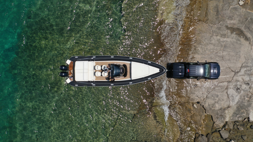 A truck backing a boat into a lake