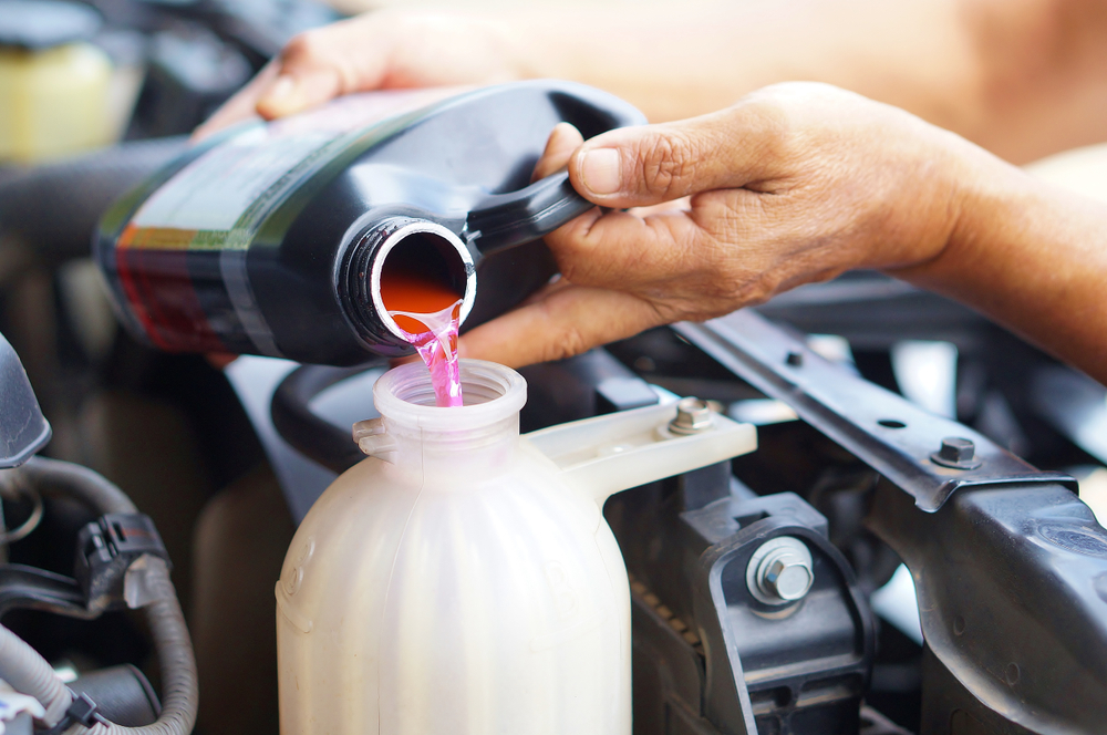 man filling car with coolant