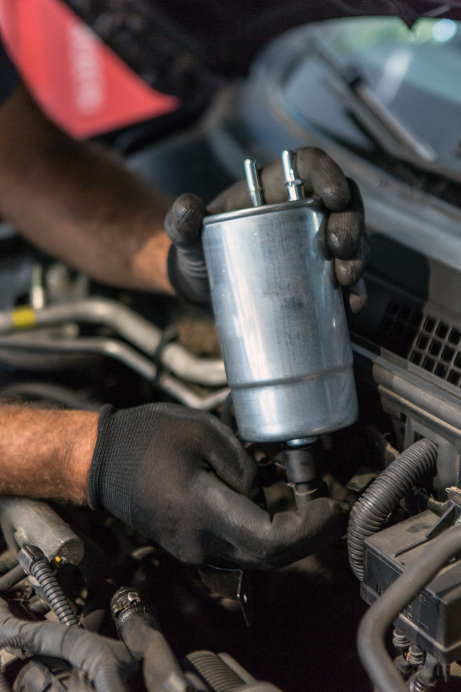 a mechanic holding a fuel filter