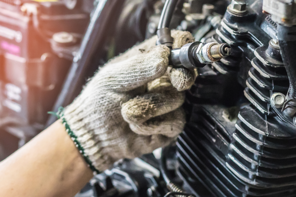 a mechanic inspects a spark plug