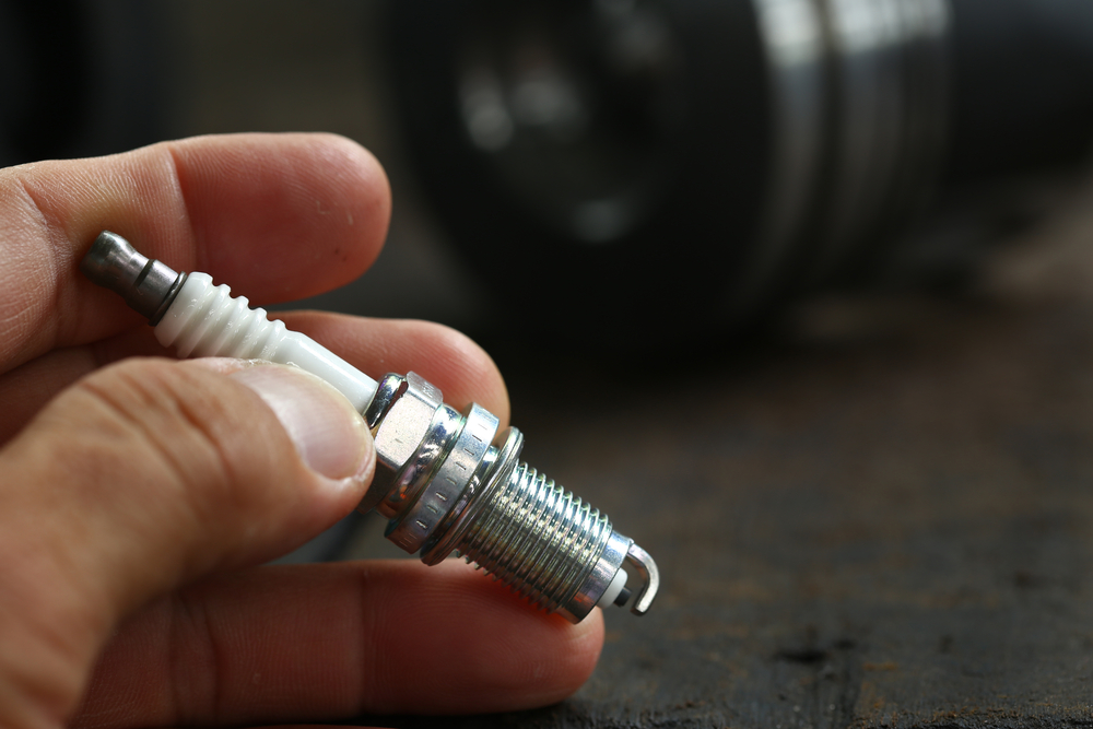 a person holding a new spark plug