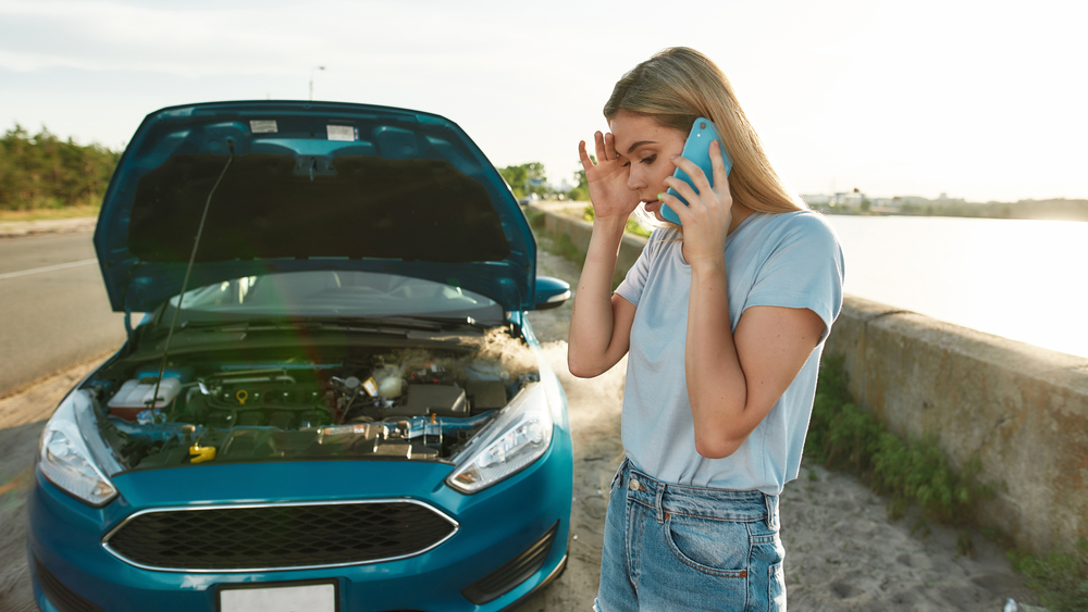 a woman and her car stranded at the side of the road