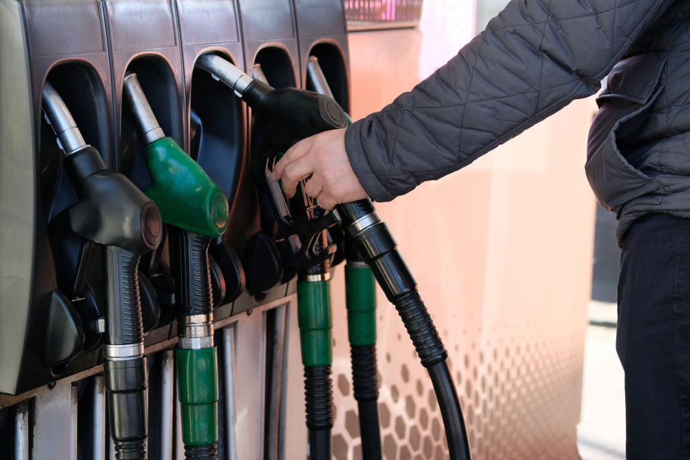 man holding pump at gas station