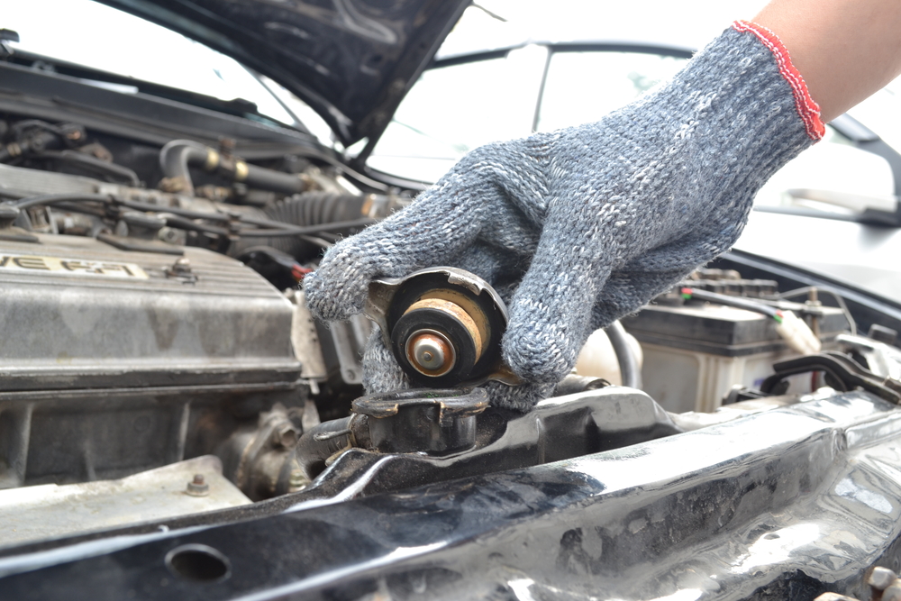 mechanic checking radiator cap