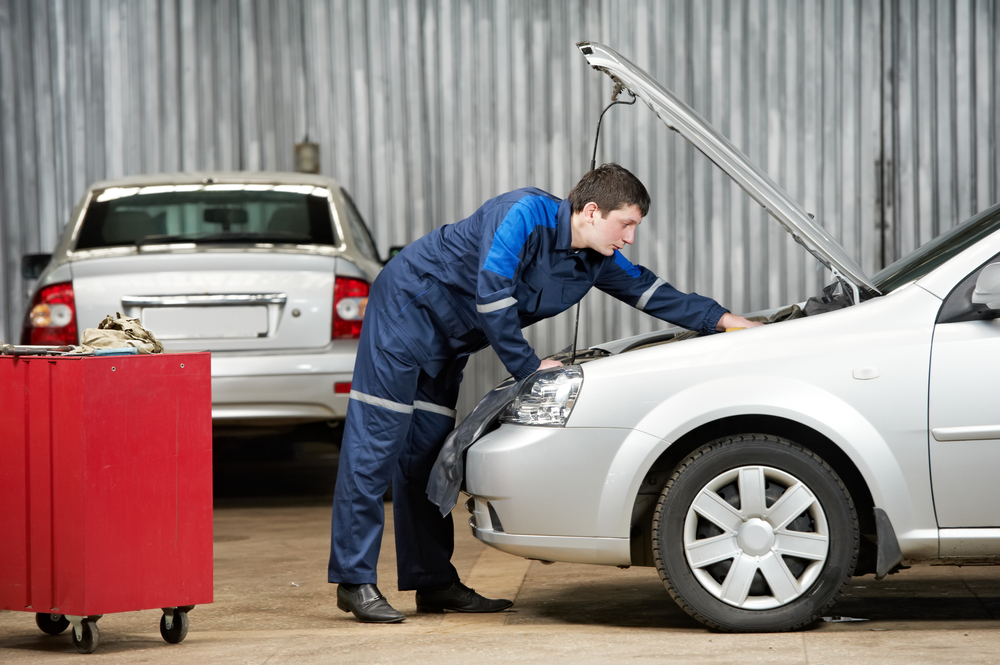 mechanic inspects a vehicles motor