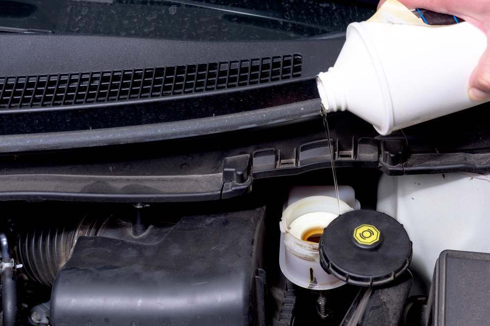 pouring dot brake fluid into a master cylinder