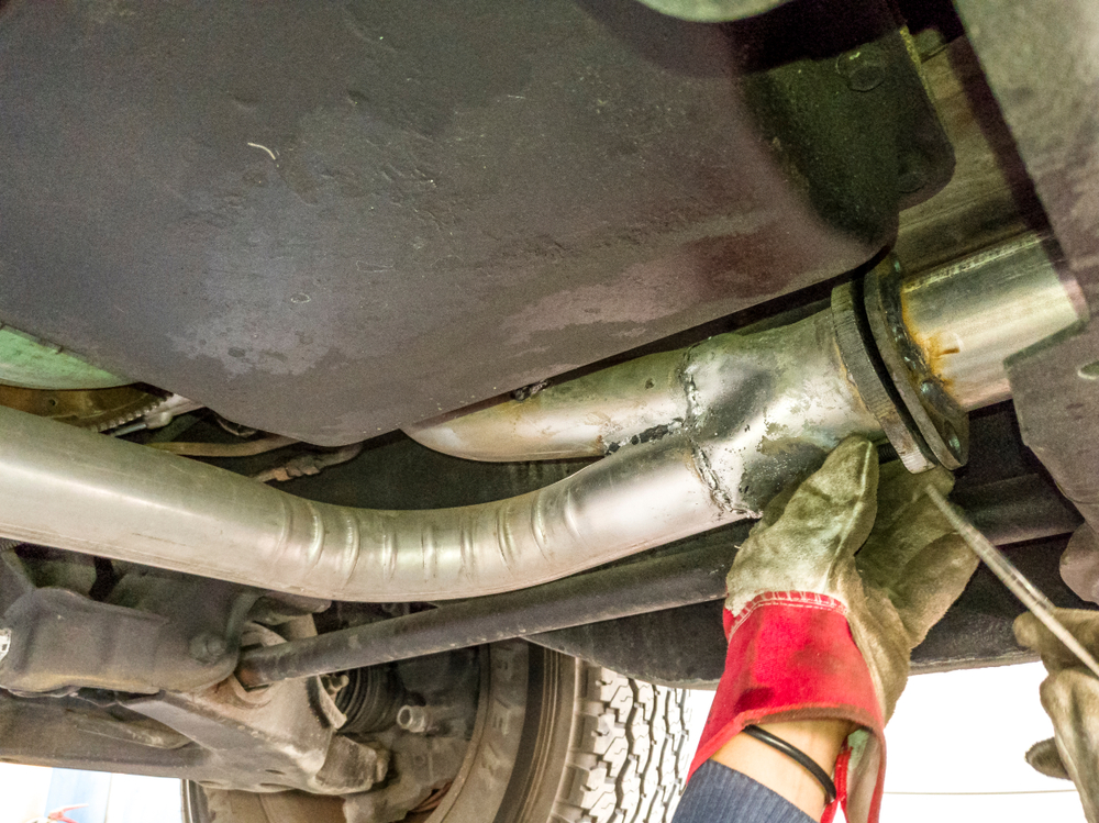 professional mechanic inspects exhaust system