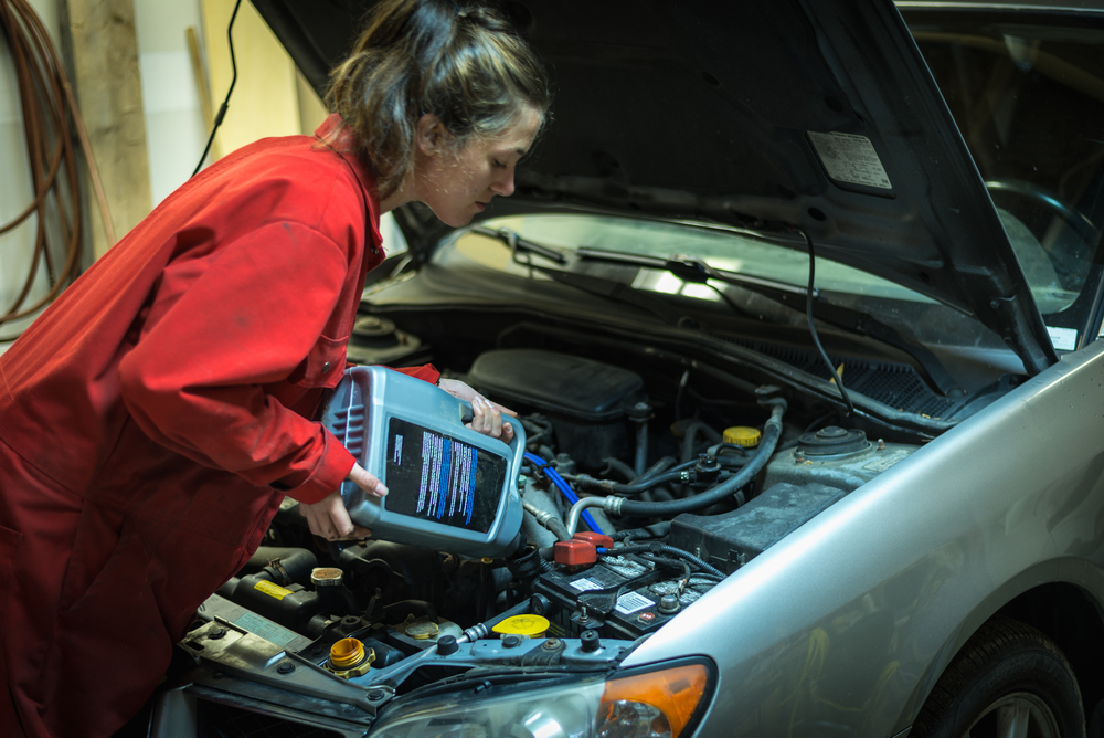 woman topping up car oil