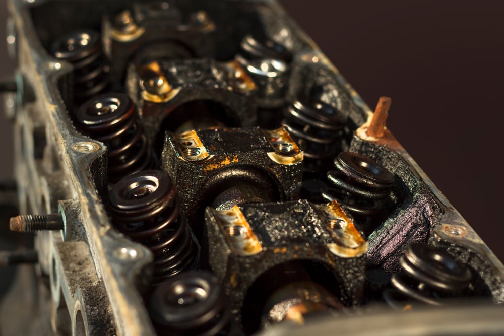 a worn and dirty engine head with visible valve springs
