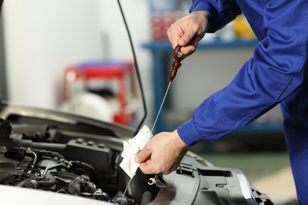 mechanic checking oil level