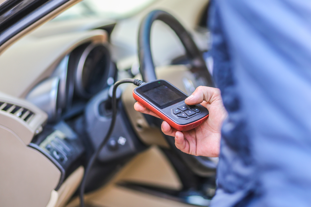 a mechanic checking fault codes with an OBD scanner