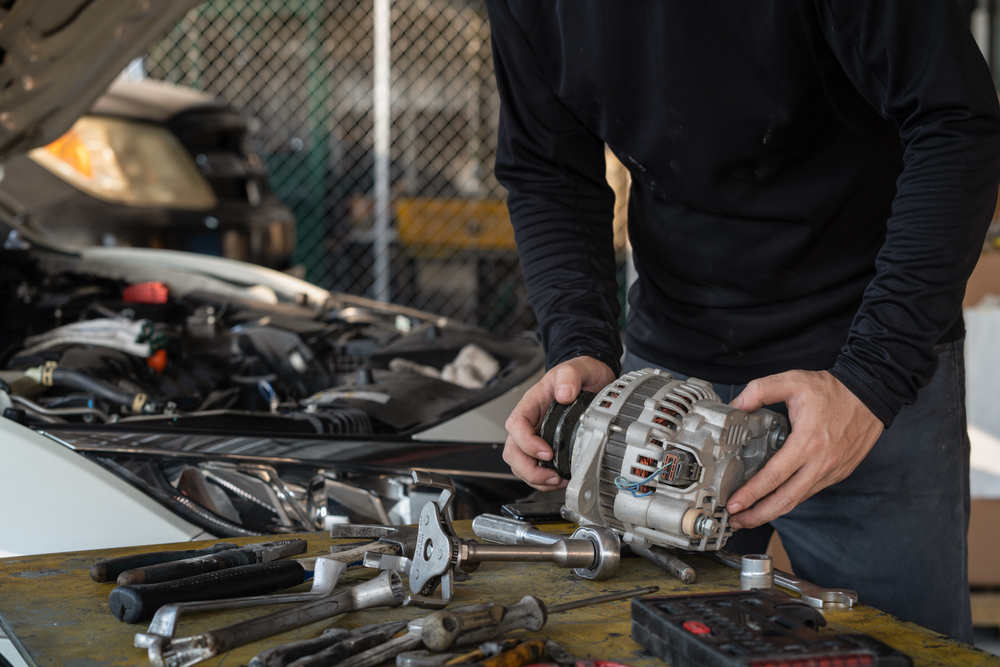 man replacing alternator