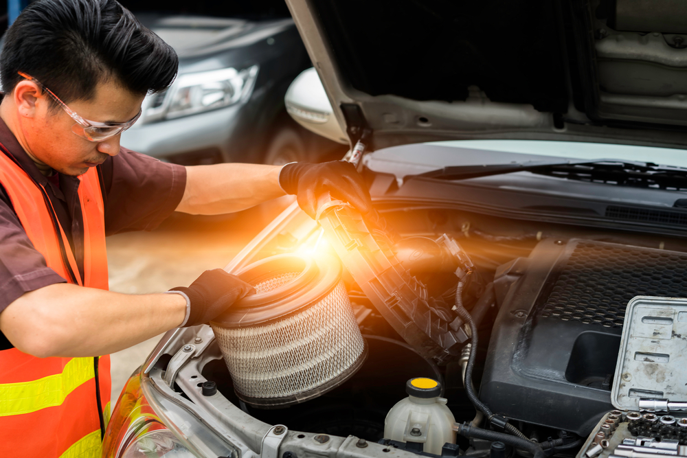 mechanic replacing a cylindrical style air filter