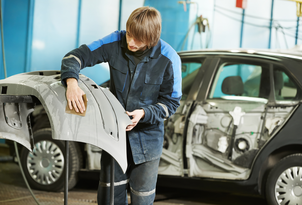 auto body technician preparing a new rear bumper for installation