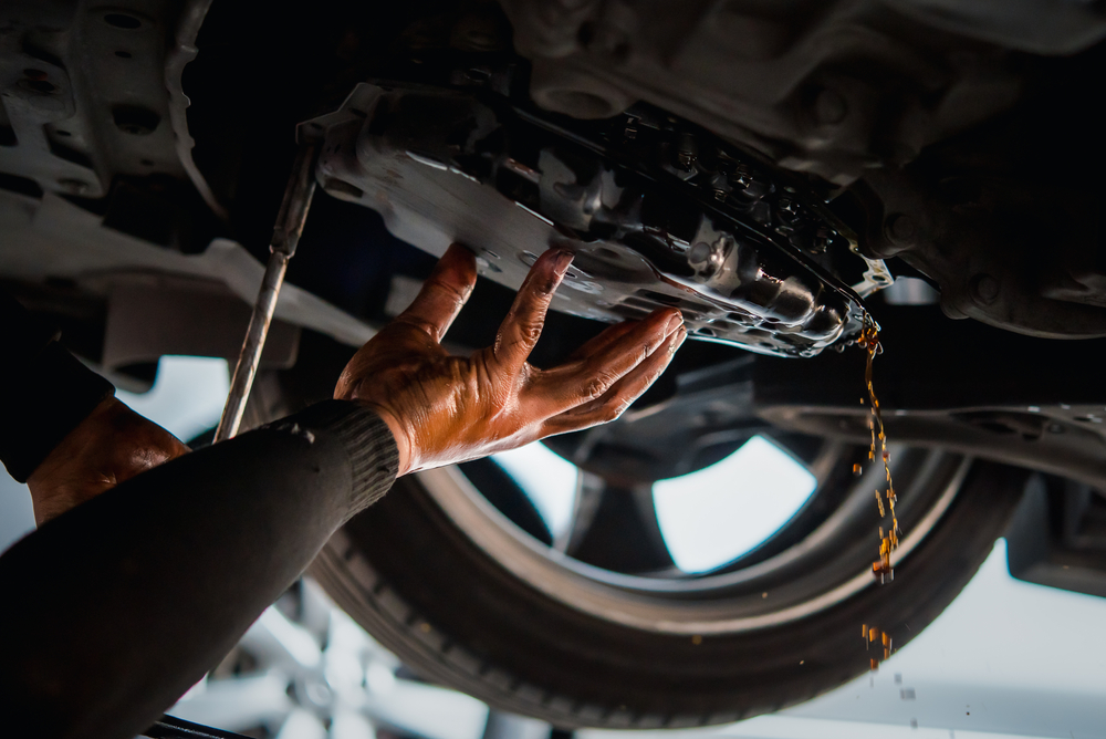 mechanic draining transmission fluid