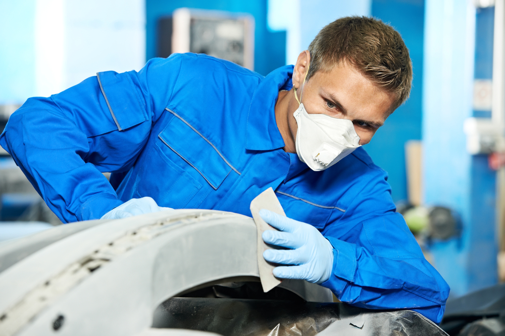 mechanic getting a rear bumper ready for installation