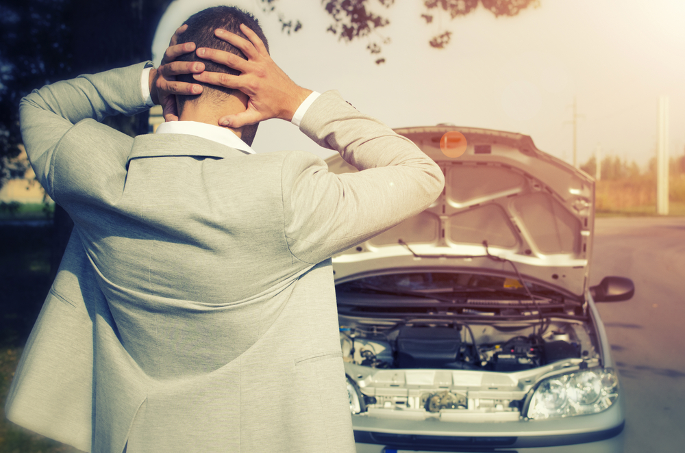 stressed man with smoking car and seized engine