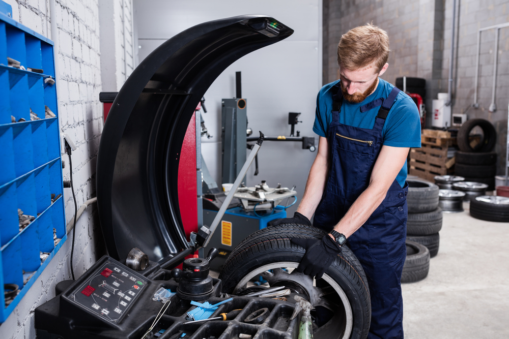 mechanic using a wheel balancing machine